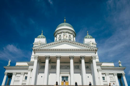 Front view of Helsinki Cathedral against a bright blue sky, highlighting neoclassical architecture