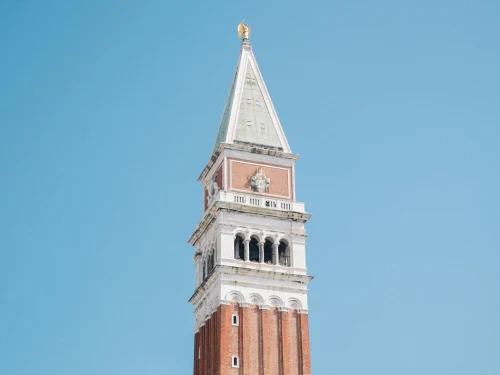 The iconic St Mark's Campanile tower in Venice, Italy set against a vibrant blue sky