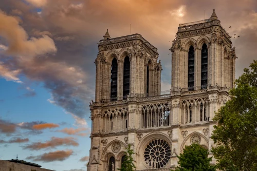 The iconic Notre-Dame Cathedral captured at sunset with dramatic skies in Paris