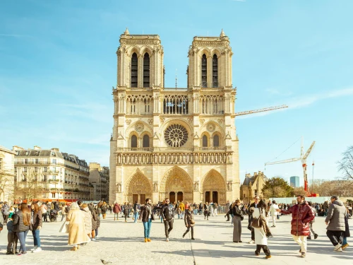 People enjoying a sunny day at Notre Dame Cathedral in Paris, France