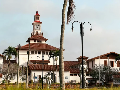 Exterior view of Balme Library at University of Ghana with palm trees and a clear sky