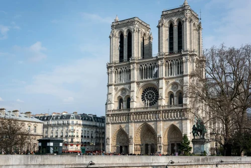 View of Notre Dame Cathedral in Paris, showcasing its Gothic architecture against a clear sky