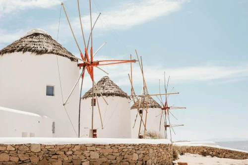 Traditional windmills on the island of Mykonos, Greece, showcasing Cycladic architecture beneath a clear blue sky