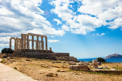 Explore the ancient Temple of Poseidon on a sunny day with a stunning ocean view, perfect for travel enthusiasts