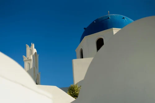 Iconic Santorini architecture with blue dome and clear sky, perfect for travel inspiration