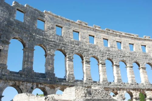 View of the iconic Roman amphitheater in Pula, Croatia, showcasing ancient architecture against a clear sky