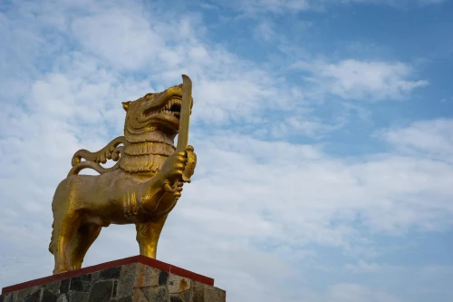 A majestic golden lion statue at Galle Face Green, Colombo under a clear blue sky