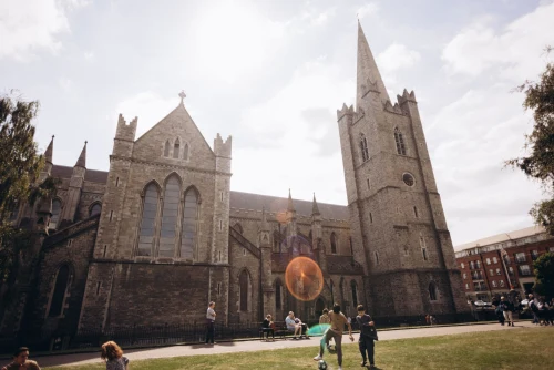 Stunning view of Saint Patrick's Cathedral with people enjoying a sunny day in Dublin, Ireland