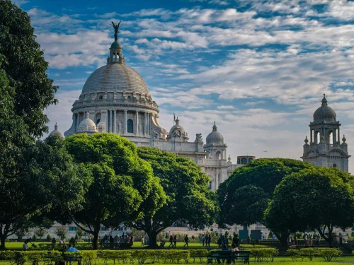 View of the iconic Victoria Memorial in Kolkata surrounded by lush greenery on a sunny day