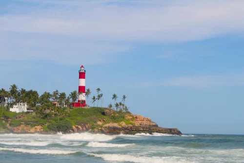 Captivating lighthouse on a rocky tropical coast with palm trees and a blue sky