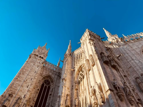 Low angle shot of the iconic Milan Cathedral against a clear blue sky in Milan, Italy