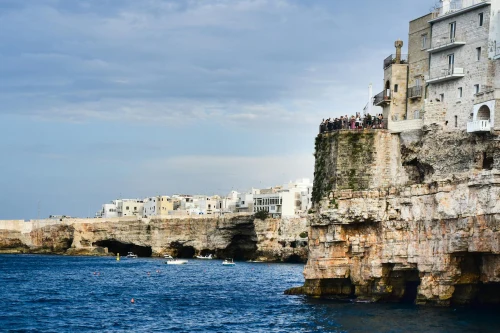 A stunning view of Polignano a Mare's famous cliffside buildings and azure sea under a blue sky
