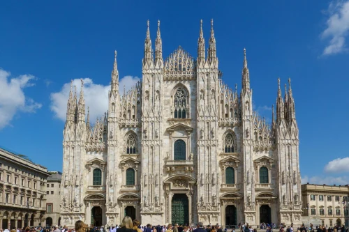 Stunning architectural view of the Milan Cathedral under a clear blue sky. A masterpiece of Gothic design