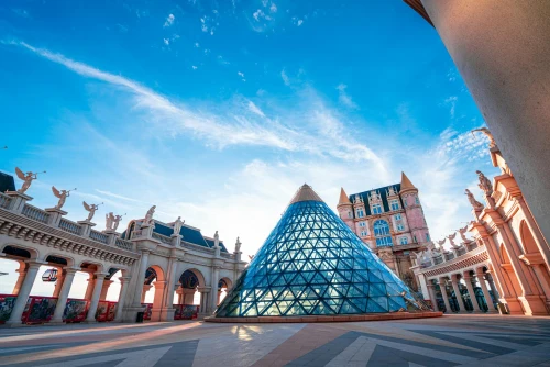 Iconic glass pyramid and arches at Ba Na Hills, Vietnam, under a vibrant blue sky