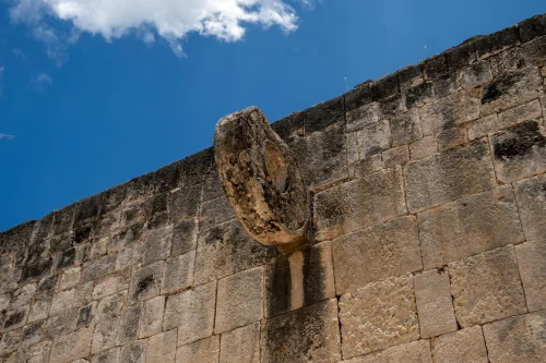 Close-up of a Mayan ball game ring on a stone wall in Chichén Itzá, under a clear blue sky