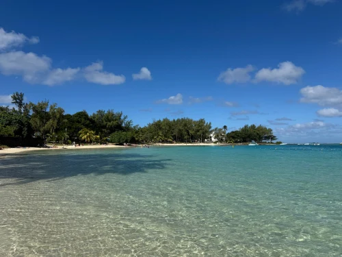 Pristine beach in Blue Bay, Mauritius with clear blue water and a sunny sky