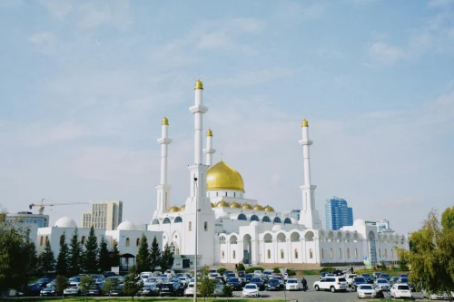 The stunning Nur-Astana Mosque in Kazakhstan with its iconic golden domes and minarets against a bright blue sky
