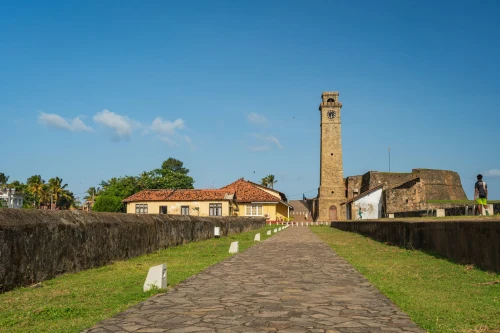 Explore the historic Galle Fort with its iconic clock tower under a clear, sunny sky