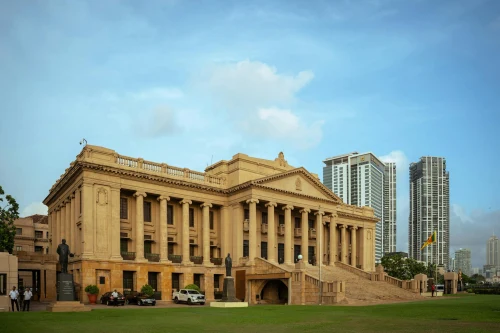 The Old Parliament Building in Colombo set against modern skyscrapers under a blue sky