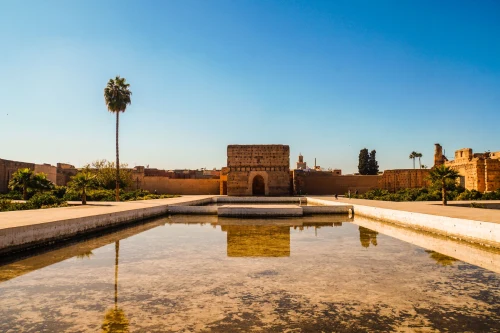 El Badi Palace in Marrakech under a clear blue sky with a reflecting pool in the foreground