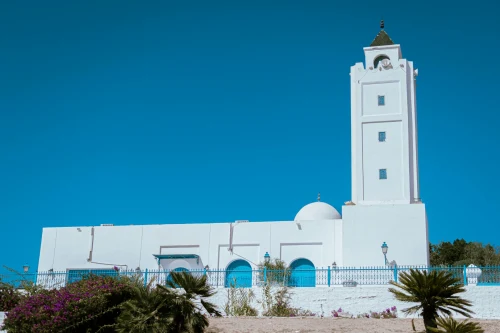 Serene white mosque with tall minaret under clear blue sky in Carthage, Tunisia