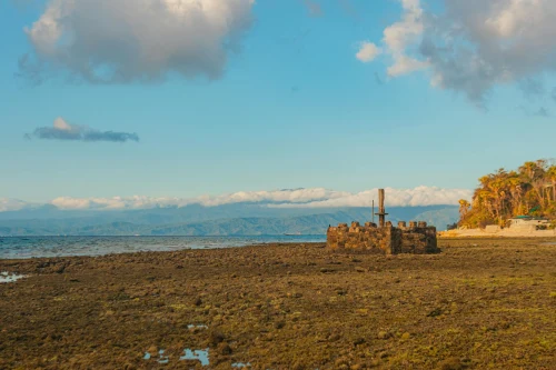 Explore ancient stone ruins on a tranquil coast under a bright blue sky