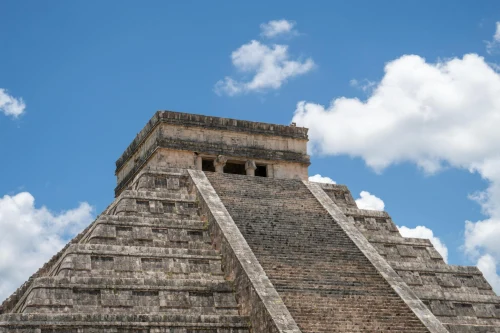 The iconic Kukulkan Pyramid at Chichén Itzá, Mexico, set against a bright blue sky
