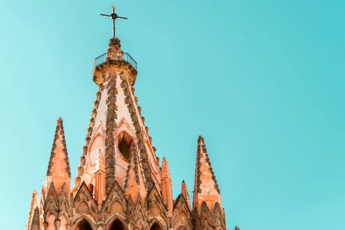 Spires of the iconic Catedral de San Miguel Arcangel against a clear blue sky in San Miguel de Allende, Mexico