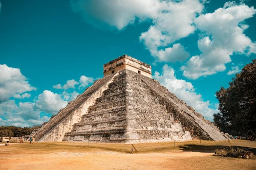 The iconic El Castillo pyramid at Chichen Itza, Mexico, captured on a sunny day with a vibrant blue sky