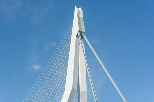 Close-up view of the iconic Erasmus Bridge in Rotterdam, showcasing its modern architecture against a clear blue sky