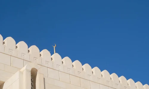 Elegant white palace battlements with symbolic crescent under a clear blue sky, showcasing architectural beauty and symbolism