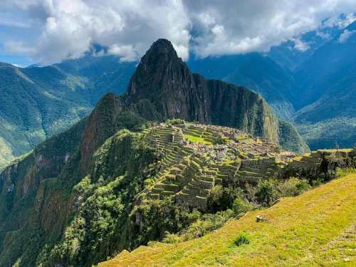 view of Machu Picchu in Peru surrounded by lush mountains and clouds