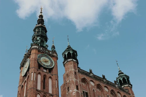 Low-angle shot of Gdańsk Town Hall's Gothic architecture and clock tower under a clear sky