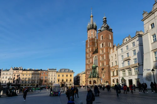 Daytime view of St. Mary's Basilica in Krakow's Main Market Square, under clear blue skies