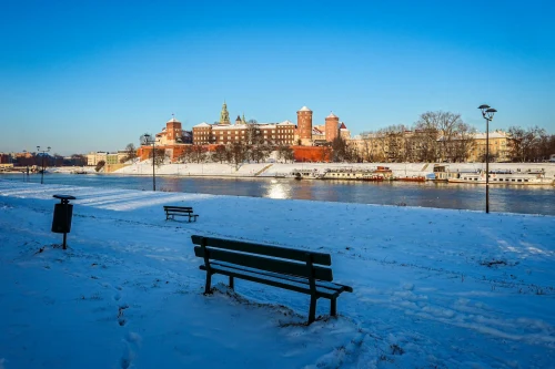 Serene winter scene captures Wawel Castle by the Vistula River in Kraków
