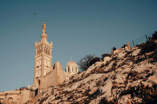 Dame de la Garde with rocky cliff in Marseille under bright summer sky