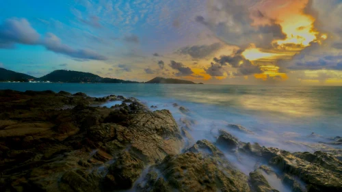 Serene view of sunset over rocky coastline at Patong Beach, Phuket, Thailand