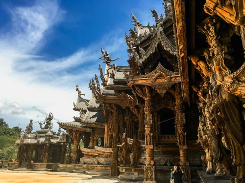 Explore the intricate wooden architecture of the Sanctuary of Truth in Pattaya, Thailand under a clear blue sky