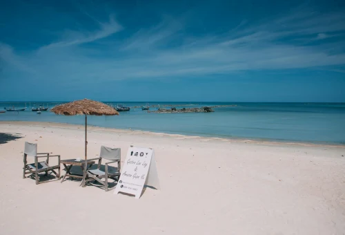 Relaxing beach view on Koh Samui with chairs and parasol under the sunny sky