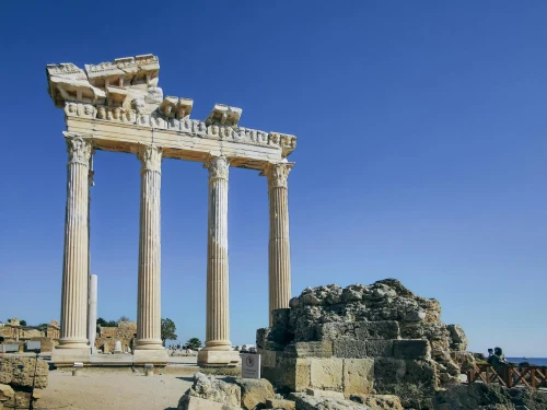 Stunning view of ancient Greek ruins with tall columns against a clear blue sky, perfect for travel inspiration
