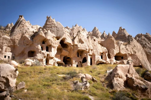 Stunning ancient rock dwellings in Cappadocia, Turkey, against a clear blue sky