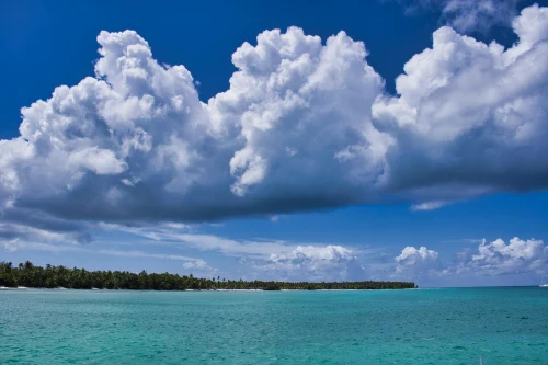 Stunning seascape of a tropical island under a bright blue sky with fluffy clouds