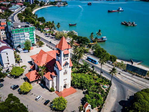 Aerial photograph of Dar es Salaam featuring a church near the coastline under a clear blue sky