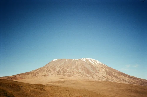 Stunning capture of Mount Kilimanjaro with its snowy peak against a clear blue sky in Tanzania