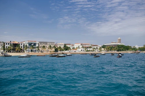 Scenic view of boats and historic Stone Town, Zanzibar under a blue sky