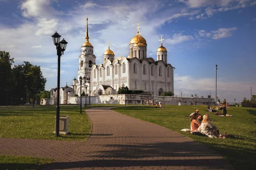 Scenic view of Vladimir's Assumption Cathedral with people enjoying a sunny day in the park