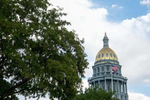 The Denver State Capitol building with its iconic gold dome under a clear blue sky