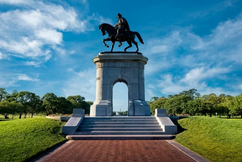 The iconic Sam Houston monument in the scenic Hermann Park, Houston, with a clear blue sky backdrop