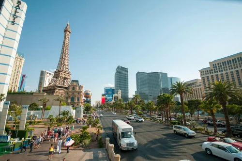 Bustling Las Vegas Strip showcasing iconic Eiffel Tower replica against a clear sky