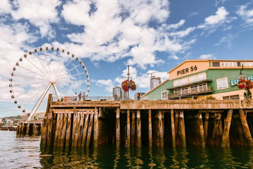 Iconic Seattle Ferris wheel and Pier 56 under a sunny sky, perfect tourist attraction